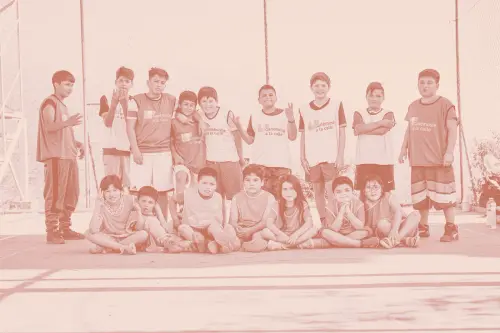 Niños y niñas de un taller deportivo posando en una cancha