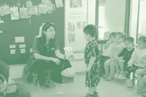 Educadora trabajando con un grupo de niños en una sala de clases